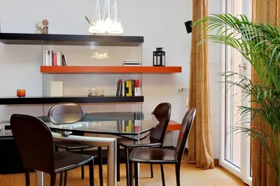 a dining room with a glass table and chairs at Angelico Family Apartment in Rome