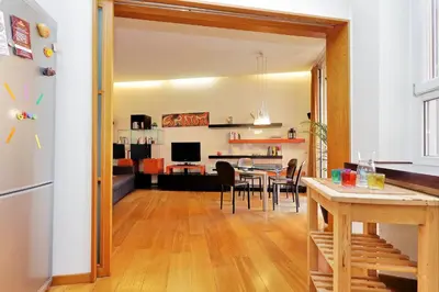 a kitchen and living room with a table and chairs at Angelico Family Apartment in Rome