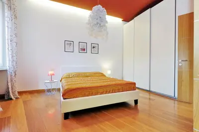 a bedroom with a bed and a chandelier at Angelico Family Apartment in Rome