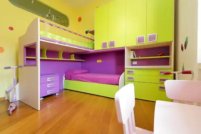 a childs bedroom with a bunk bed with pink and green cabinets at Angelico Family Apartment in Rome