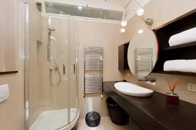 a bathroom with a shower and a sink and a mirror at Angelico Family Apartment in Rome
