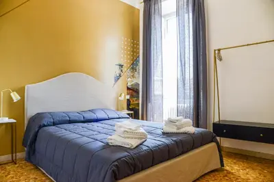 a bedroom with a blue bed with towels on it at San Pietro Suite Rome in Rome