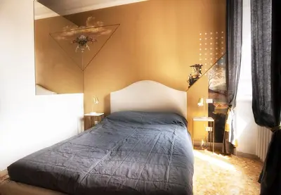 a bedroom with a bed with a blue comforter at San Pietro Suite Rome in Rome