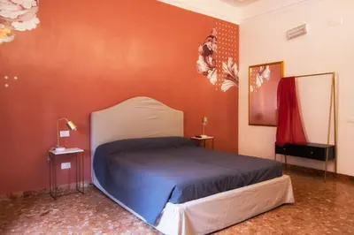 a bedroom with a bed in a red wall at San Pietro Suite Rome in Rome