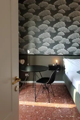 a bedroom with a desk and a bed and a wall with clouds at Cavour Urban Rooms by GHOR in Rome