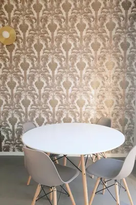 a dining room with a table and chairs against a damask wallpaper at Cavour Urban Rooms by GHOR in Rome