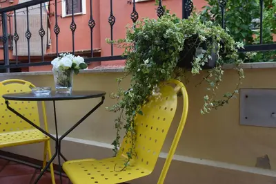 a table and two chairs with flowers on a balcony at Diasof Apartments in Rome