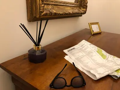 a table with a newspaper and a pair of glasses on it at Visione Via Sant’Andrea delle Fratte, 36 in Rome