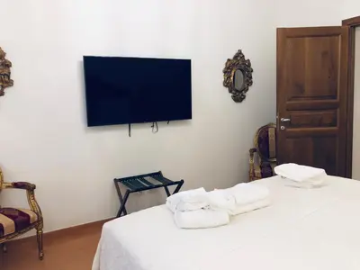 a room with two towels on a bed with a flat screen tv at Visione Via Sant’Andrea delle Fratte, 36 in Rome