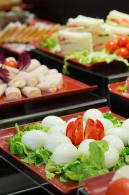 a display of vegetables and cheese on red plates at Floris Hotel in Rome