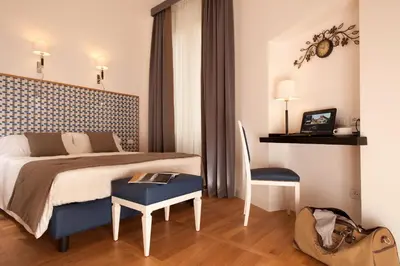 a bedroom with a bed and a table and a chair at Floris Hotel in Rome