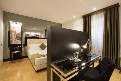 a hotel room with a bed and a desk at Floris Hotel in Rome