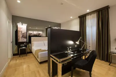 a hotel room with a bed and a desk in a room at Floris Hotel in Rome