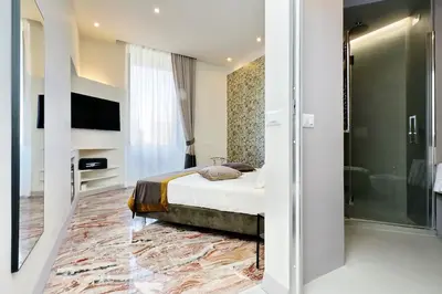 a hotel room with a bed and a walk in shower at Opera 58 - Teatro dell'Opera Suites in Rome