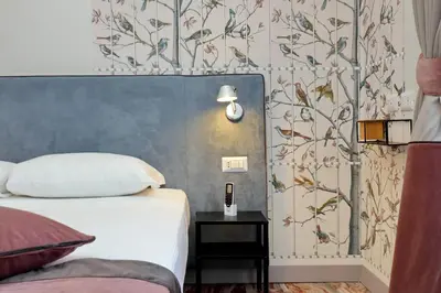 a bedroom with a bed with a blue headboard at Opera 58 - Teatro dell'Opera Suites in Rome