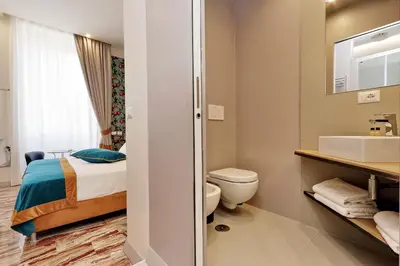 a bathroom with a bed and a toilet and a sink at Opera 58 - Teatro dell'Opera Suites in Rome