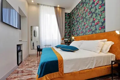 a bedroom with a large bed and a fireplace at Opera 58 - Teatro dell'Opera Suites in Rome