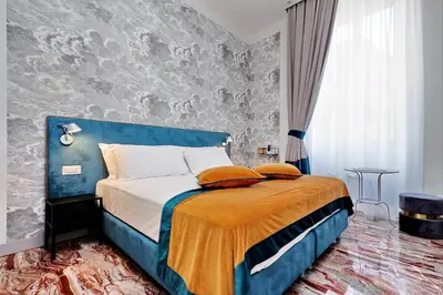a bedroom with a bed with a blue headboard at Opera 58 - Teatro dell'Opera Suites in Rome