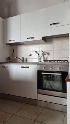a kitchen with a stainless steel stove and white cabinets at Studio della Pace, Classy & Charming - RENOVATED in Rome