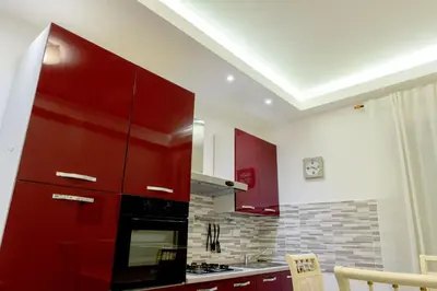 a kitchen with red cabinets and a stove at La Maison In Rome in Rome