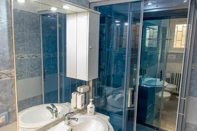 a bathroom with a sink and a glass shower at La Maison In Rome in Rome