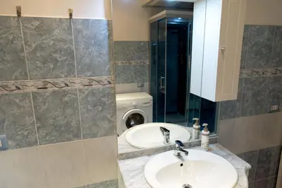 a bathroom with a sink and a washing machine at La Maison In Rome in Rome