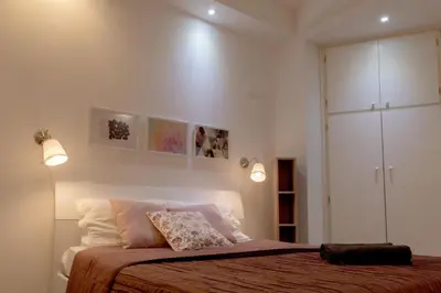 a bedroom with a bed with two lights on it at La Maison In Rome in Rome