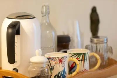 two coffee cups sitting on a counter next to a toaster at Kings Home In Rome in Rome