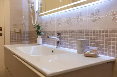 a bathroom with a white sink and a mirror at Kings Home In Rome in Rome