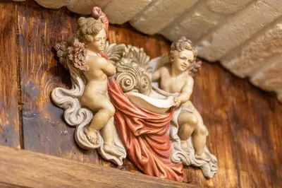 a couple of angel statues on a wooden wall at Kings Home In Rome in Rome