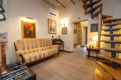 a living room with a couch and a staircase at Kings Home In Rome in Rome