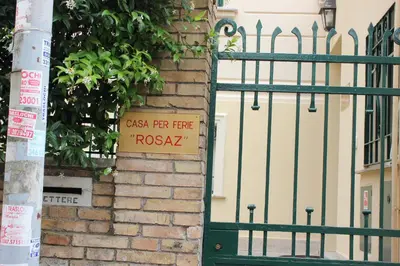 a gate with a sign on it next to a building at Casa per Ferie Beato Rosaz in Rome