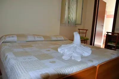 a bed with white sheets on top of it at Casa per Ferie Beato Rosaz in Rome