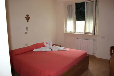 a bedroom with a bed with red sheets and a window at Casa per Ferie Beato Rosaz in Rome