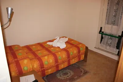 a bedroom with a bed with a towel on it at Casa per Ferie Beato Rosaz in Rome