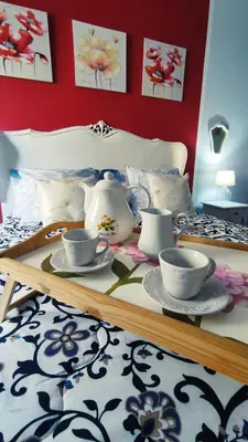 a table with tea cups and saucers on a bed at Garbatella Chippendale Apartment in Rome