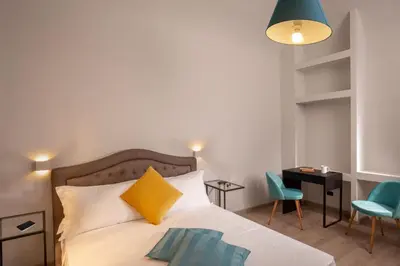 a bedroom with a bed and a desk and chairs at The Shell Rome Suite in Rome