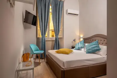 a bedroom with a bed and a chair and a window at The Shell Rome Suite in Rome