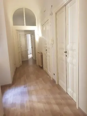 an empty hallway with white doors and wooden floors at The Shell Rome Suite in Rome