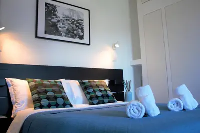 a bedroom with a bed with blue sheets and pillows at VATICAN APARTMENT MELORIA in Rome