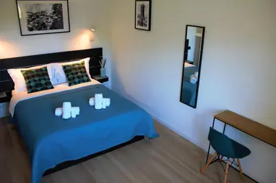 a bedroom with a bed with blue sheets and a mirror at VATICAN APARTMENT MELORIA in Rome