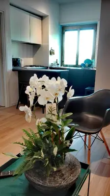 a vase with white flowers on a table in a room at VATICAN APARTMENT MELORIA in Rome
