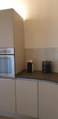 a kitchen with white cabinets and a white microwave at Luxury House Colosseo in Rome