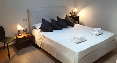 a bedroom with a large white bed with towels on it at Luxury House Colosseo in Rome