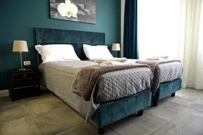 a bedroom with a large bed with a blue wall at Regolo Rooms Vaticano in Rome