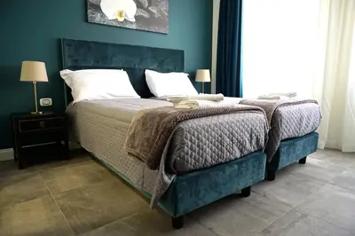 a bedroom with a large bed with a blue wall at Regolo Rooms Vaticano in Rome
