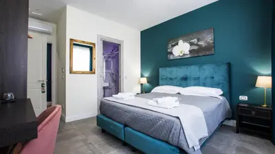 a bedroom with a large bed with a blue wall at Regolo Rooms Vaticano in Rome