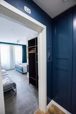 a room with a blue wall with a bed and a door at Regolo Rooms Vaticano in Rome