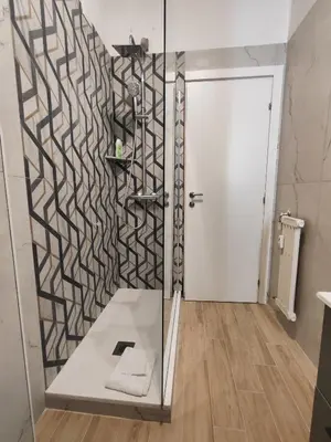 a bathroom with a shower with a glass door at Chroma Italy - Doctor House in Rome