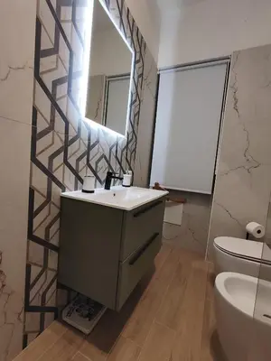 a bathroom with a sink and a mirror and a toilet at Chroma Italy - Doctor House in Rome
